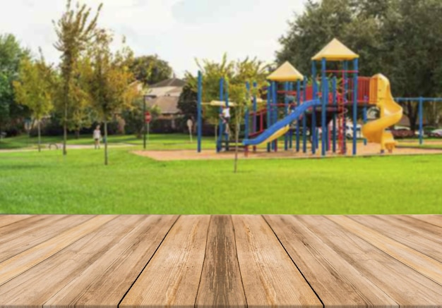 Tavolo in legno vuoto con parco per bambini sullo sfondo