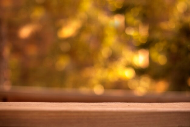 Tavolo in legno vuoto davanti a sfondo sfocato