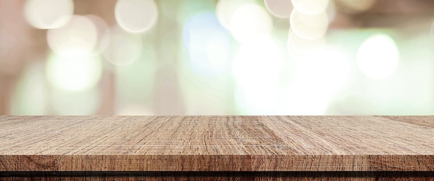 Tavolo in legno vuoto su negozio sfocato con sfondo bokeh