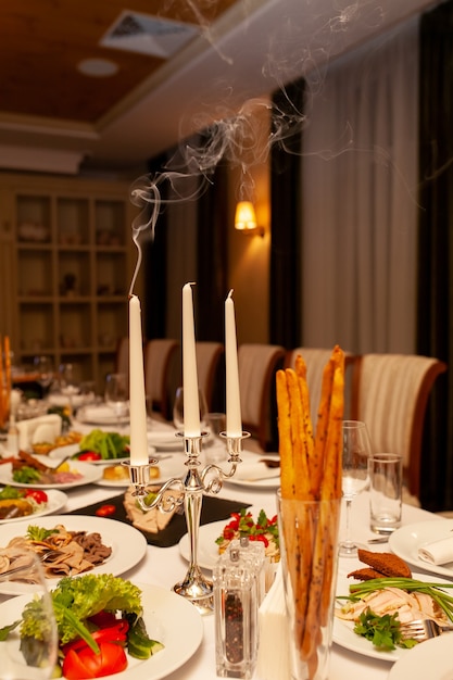 Tavolo lussureggiante per banchetti con candele e cibo