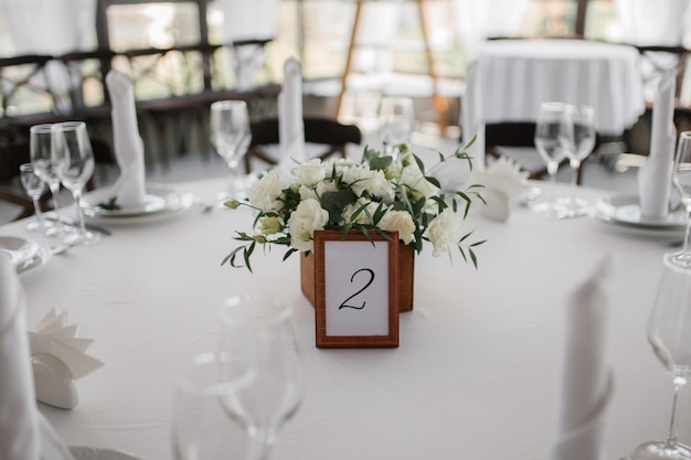 Tavolo nuziale decorato per gli invitati con un numero e una scatola di fiori