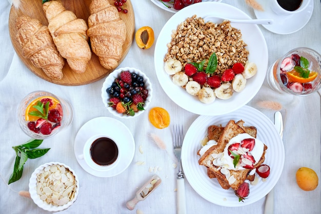 Tavolo per la colazione continentale fresco e luminoso, varietà di pasti sani in abbondanza