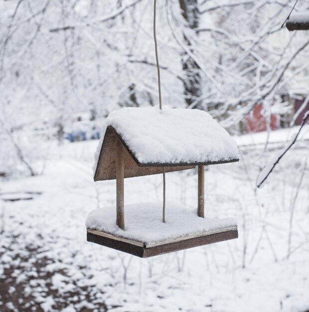 Tavolo per uccelli in legno ricoperto di neve