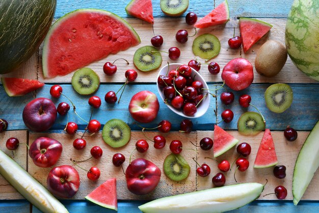 Tavolo rustico pieno di pezzi di anguria, melone