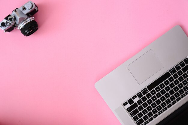 Tavolo scrivania da ufficio con laptop, macchina fotografica e caffè lenti.