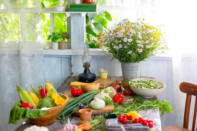 Tavolo sulla veranda della casa del villaggio di campagna con verdure diverse cibo ecologico dalla raccolta autunnale del giardino