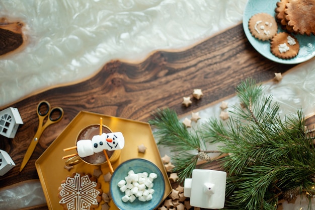 Tavolo Topview con decorazioni natalizie. Pupazzi di neve di marshmallow decorati con glassa di zucchero. Biscotti di pan di zenzero sotto forma di fiocchi di neve.