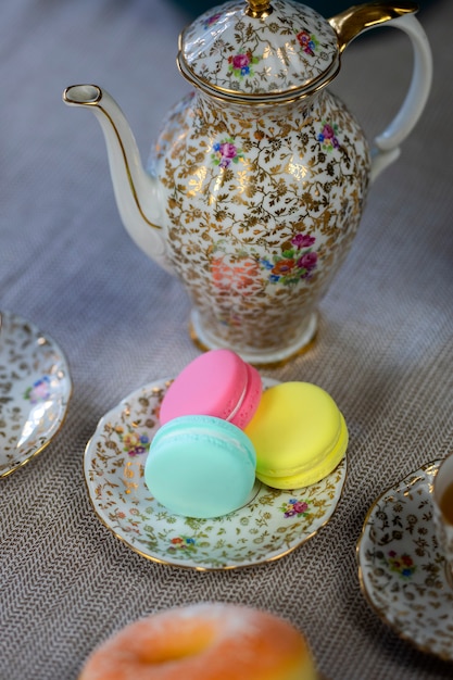 Tavolo tradizionale con tazza di tè e teiera e macaron colorato delizioso tavolo accogliente a casa, impostazione del tè per la festa della mamma con teiera,