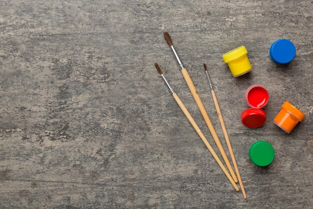 Tavolozza artistica con vernice e pennelli da vicino Vista dall'alto con spazio vuoto per il disegno del concetto di insegnamento domestico della creatività