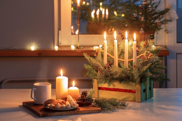Tazza bianca con bevanda calda e decorazioni natalizie a casa