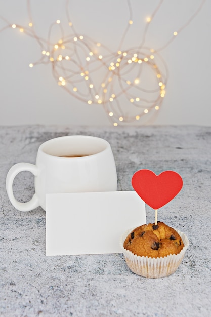 Tazza bianca con cuori e muffin al cioccolato rosso caramelle al cioccolato