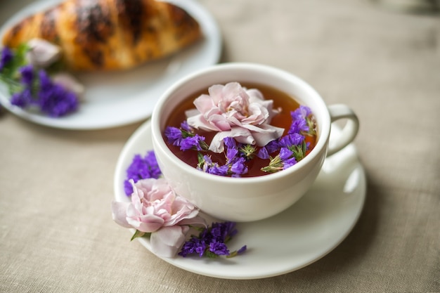 Tazza bianca con fiori galleggianti di tè