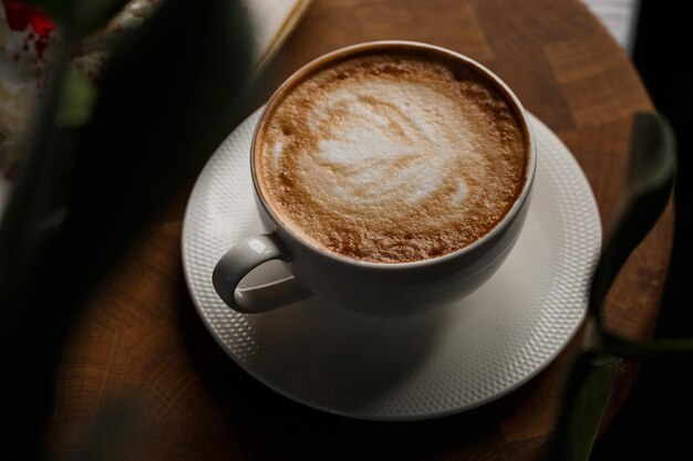 Tazza bianca di caffè caldo latte con bella schiuma di latte latte art texture isolata su sfondo scuro Vista dall'alto spazio copia Pubblicità per menu bar Menu caffetteria