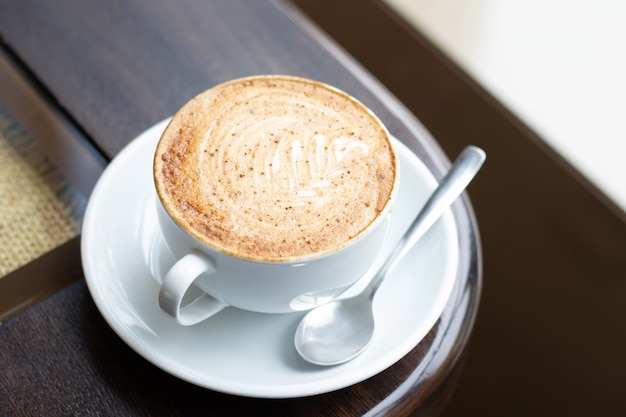 Tazza bianca di cappuccino art cappuccino con bella schiuma. Primo piano, messa a fuoco selettiva.