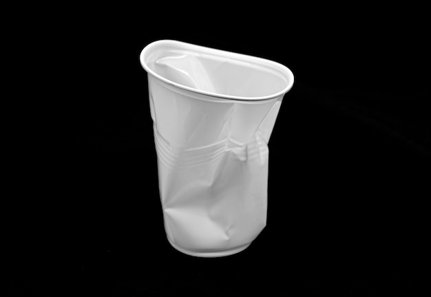 Tazza bianca di plastica sgualcita isolata