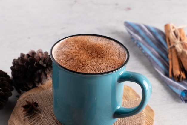 Tazza blu con bevanda al cioccolato e cannella