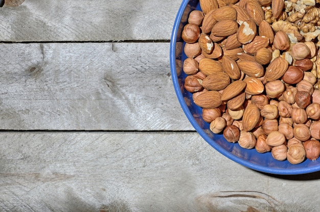 Tazza blu con noci su uno sfondo di legno