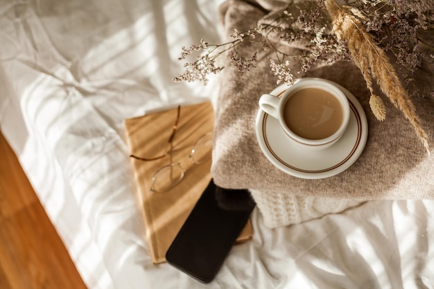 Tazza calda di cappuccino sul vassoio di legno sul letto colazione bouquet di fiori secchi Scenario primaverile Casa accogliente Colori naturali beige