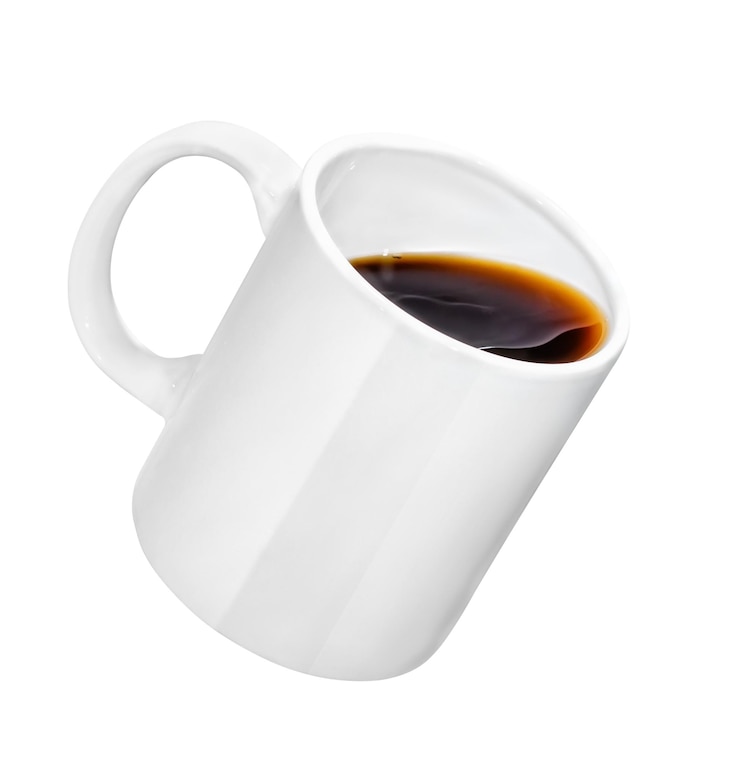 Foto tazza che cade con caffè o tè isolato su priorità bassa bianca