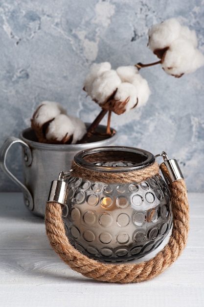 tazza con fiori di cotone e candele accese