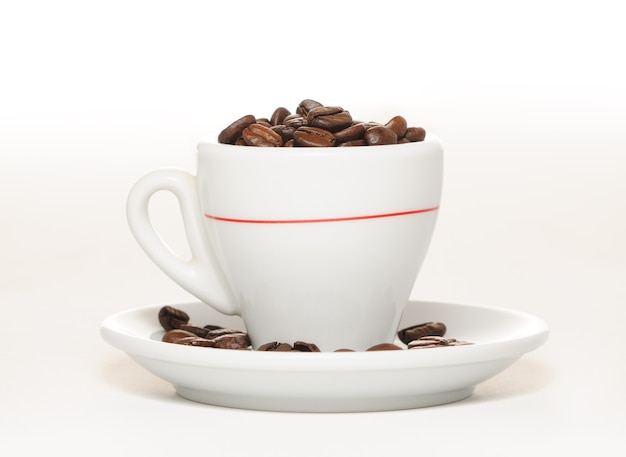 Tazza con mucchio di chicchi di caffè