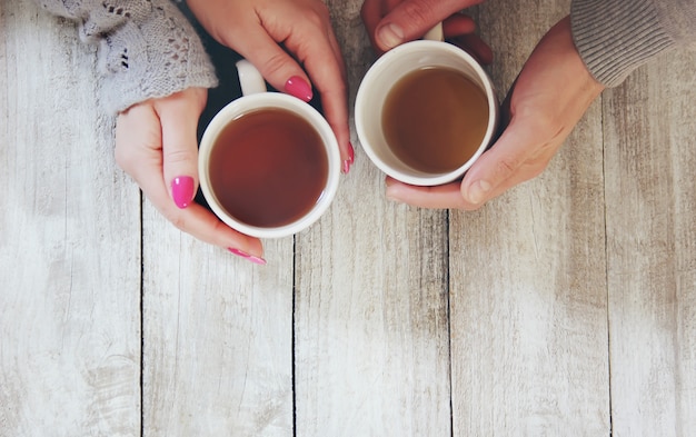 Tazza da bere per la colazione nelle mani degli innamorati. Messa a fuoco selettiva