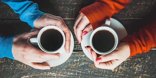 Tazza da bere per la colazione nelle mani degli innamorati. Messa a fuoco selettiva