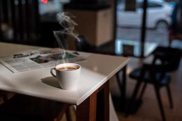 Tazza da caffè bianca sul tavolo all'interno del bar