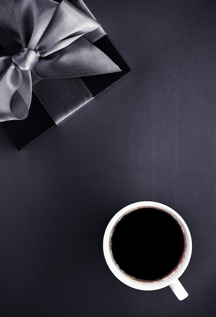 Tazza da caffè di lusso e confezione regalo su sfondo nero flatlay