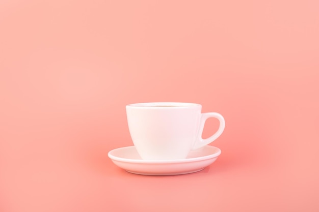 Tazza da caffè in ceramica vuota bianca a tema colazione e caffè su sfondo rosa che fa pubblicità al caffè