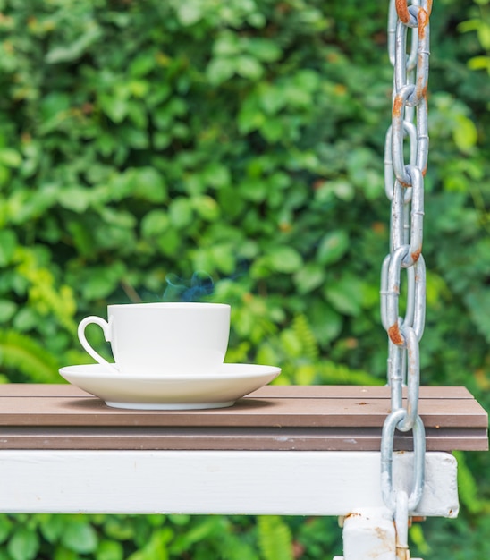 Tazza da caffè sul sedile sospesa da catene