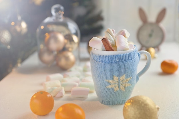 Tazza da tè blu con caramelle marshmello e decorazioni natalizie Tempo di sfondo invernale a casa accogliente