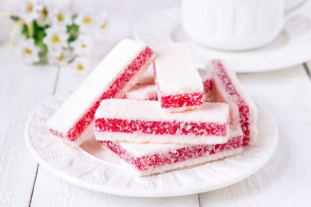 Tazza da tè da dessert al cocco e lampone su sfondo bianco