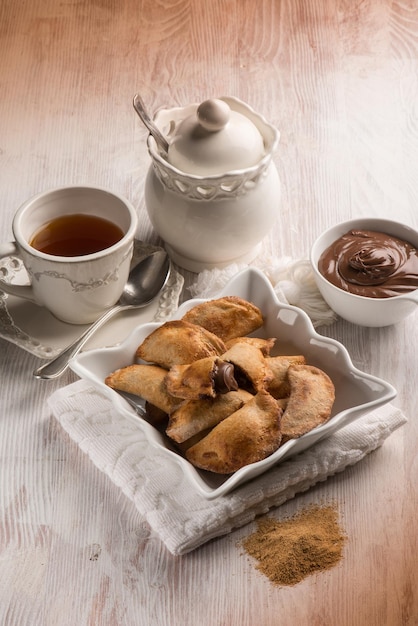 Tazza da tè e biscotto ripieni di crema al cioccolato