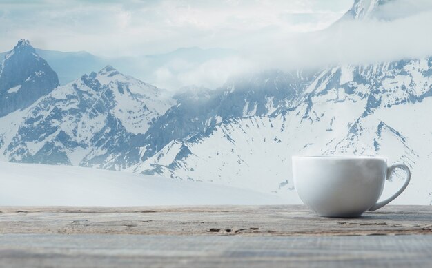 Tazza da tè o caffè singola e paesaggio di montagne sullo sfondo