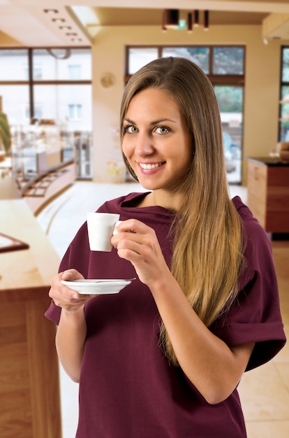 Tazza da the felice splendida della tenuta della donna in bistrot