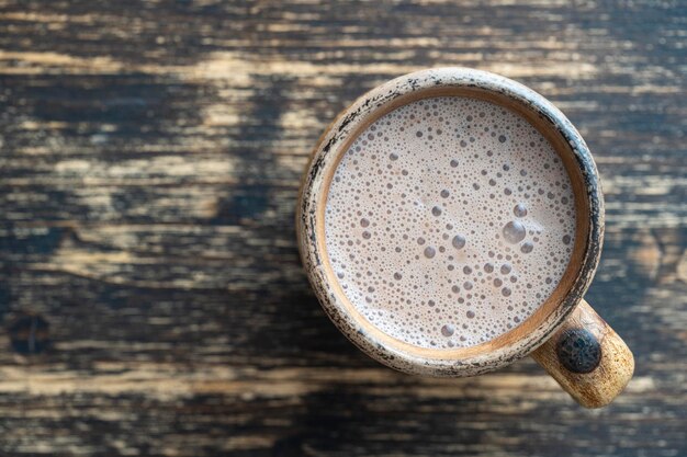 Tazza di argilla di milkshake al cioccolato su sfondo di legno Spazio per la copia della vista dall'alto