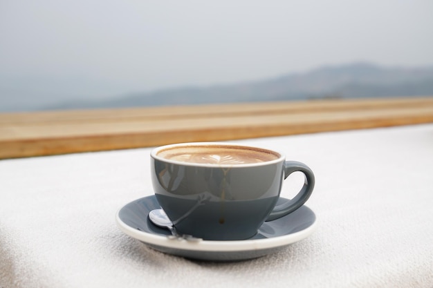 Tazza di arte del latte caldo sulla tavola bianca.