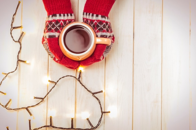 Tazza di bevanda calda a freddo. Una tazza di caffè o tè caldo in muffole. Bevanda riscaldante Concetto di Natale