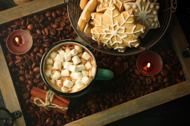 Tazza di cacao caldo con marshmallow e biscotti su chicchi di caffè