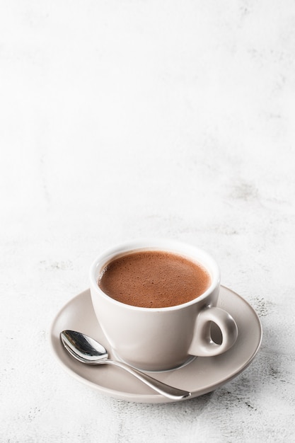 Tazza di cacao caldo o cioccolata calda o americano in tazza bianca isolata su fondo di marmo luminoso. Vista dall'alto, copia spazio. Pubblicità per menu bar. Menu della caffetteria. Foto verticale. tradizionale