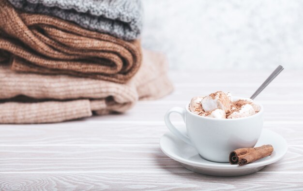 Tazza di cacao e mucchio di maglieria