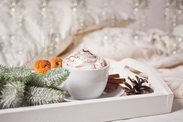 Tazza di cacao sul vassoio bianco sulla mattina di inverno in anticipo del letto