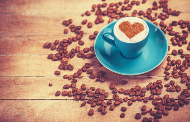 Tazza di caffè a forma di cuore su un tavolo di legno