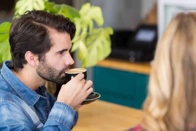 Tazza di caffè bevente dell'uomo in caffè