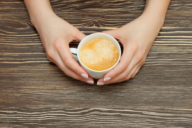 Tazza di caffè bianca in mano femminile