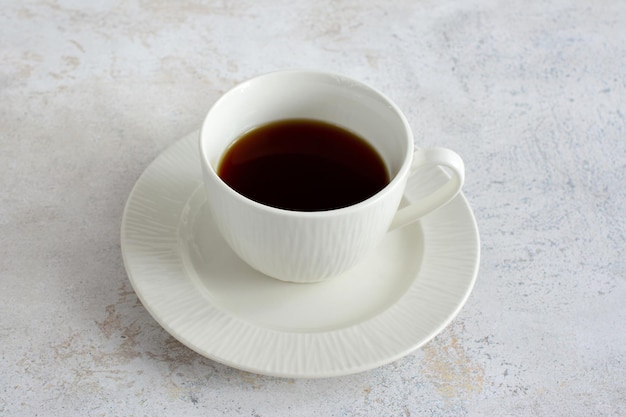 tazza di caffè bianca sul piattino bianco isolato su sfondo pastello, primo piano