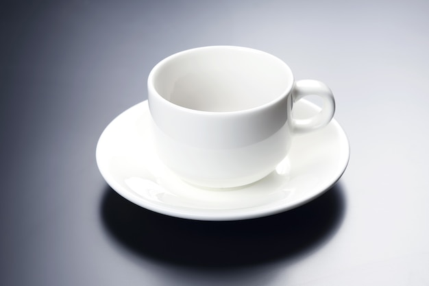 Tazza di caffè bianca vuota su sfondo blu bianco