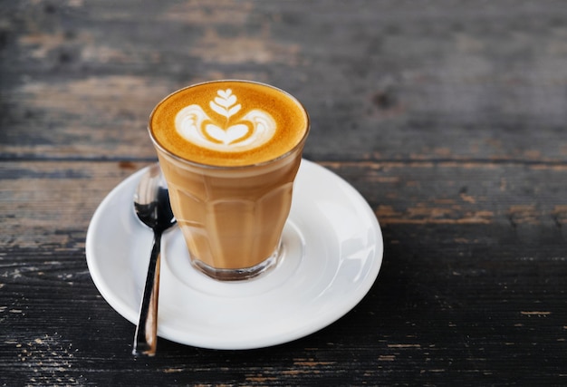 Tazza di caffè bianco piatto su un tavolo di legno