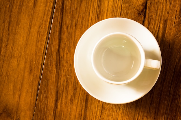 Tazza di caffè bianco vuota di vista superiore sulla tavola di legno